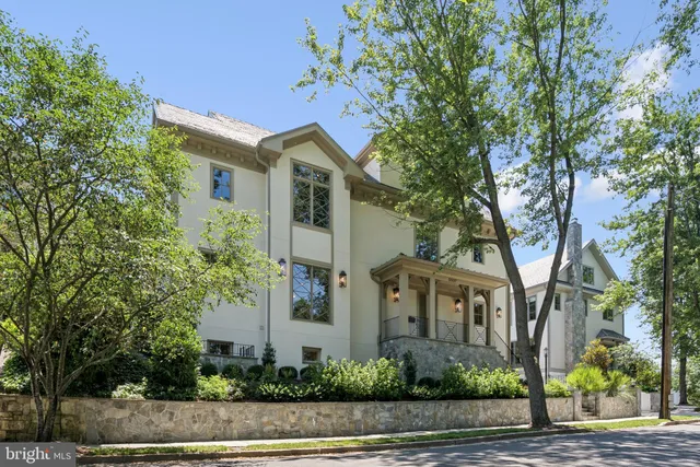 a front view of a house with a yard and tree s