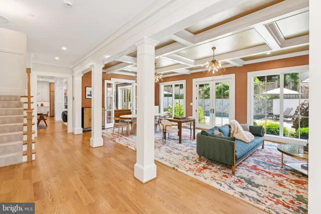 a living room with furniture large wooden floor and a large window