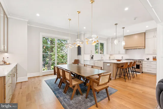a view of a dining room and livingroom with furniture wooden floor a chandelier