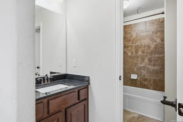 a bathroom with a granite countertop sink and a mirror
