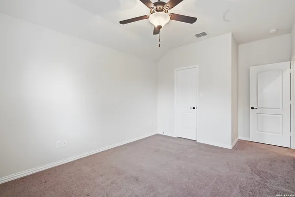 an empty room with a window and a fan