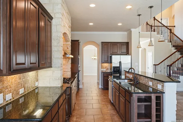 a kitchen with stainless steel appliances granite countertop a sink and stove
