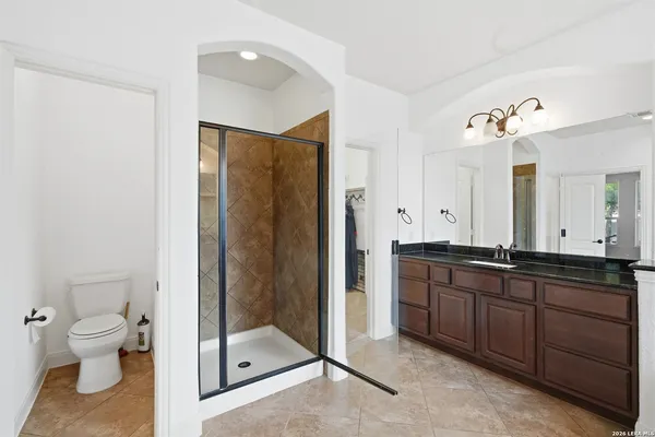 a spacious bathroom with a double vanity sink toilet and shower