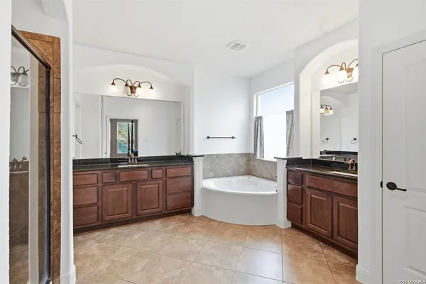a bathroom with a tub sink and mirror