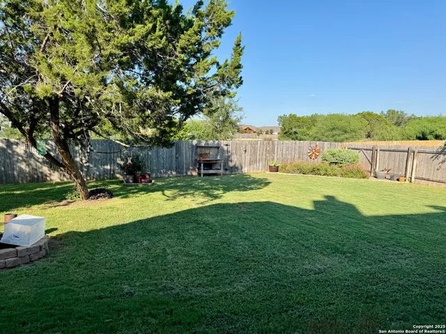 a view of a white house with a swimming pool and next to a yard