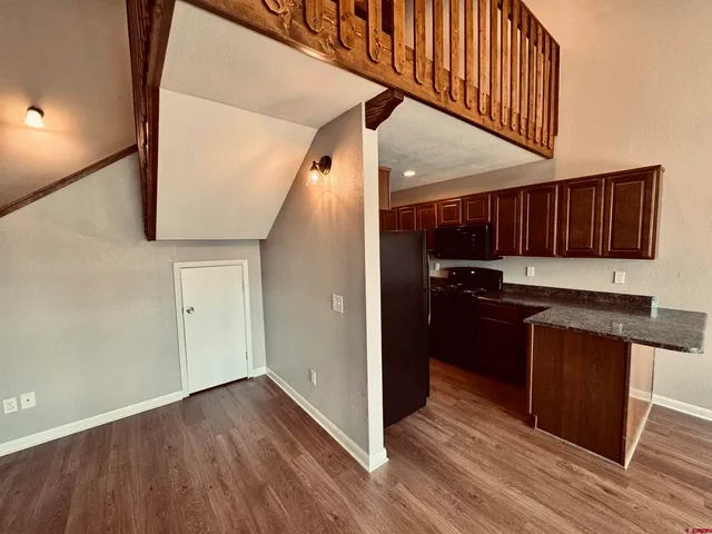 a kitchen with granite countertop wooden floors and stainless steel appliances