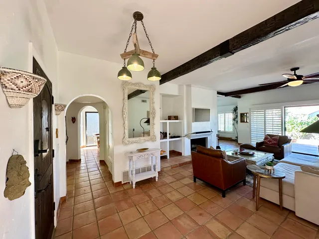 a living room with furniture a chandelier and fireplace