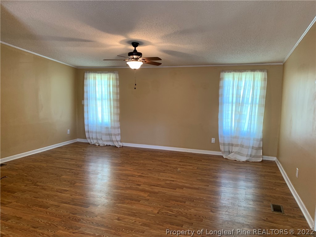 228 L A Sandy Road Raeford, NC 28376 - Photo 16 of 36 a view of an empty room with wooden floor and a window