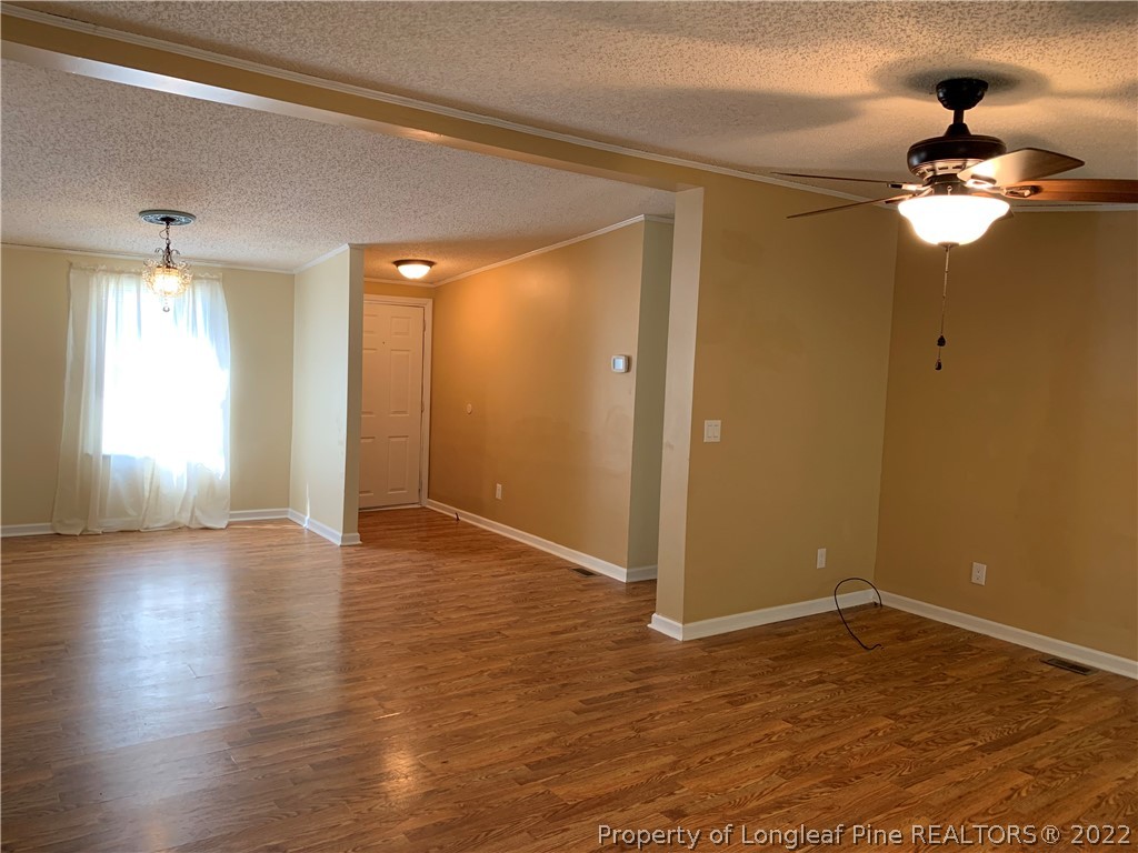 228 L A Sandy Road Raeford, NC 28376 - Photo 18 of 36 a view of empty room with wooden floor and fan