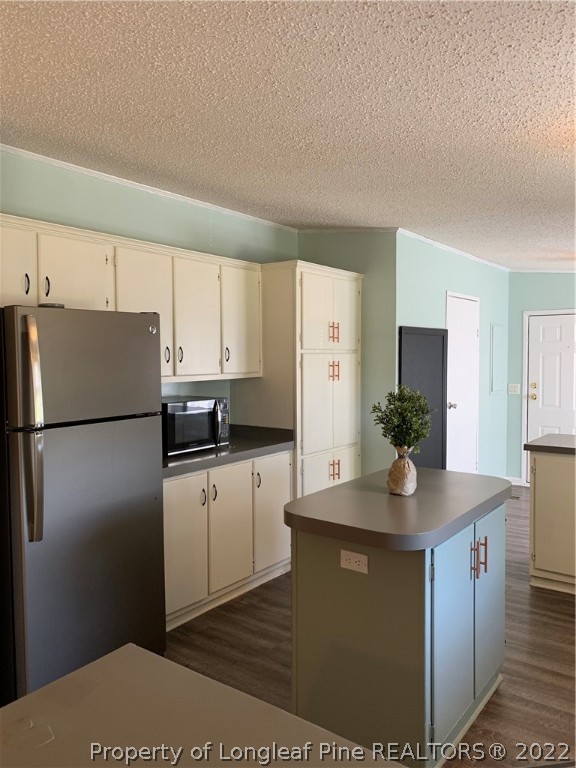 228 L A Sandy Road Raeford, NC 28376 - Photo 9 of 36 a kitchen with kitchen island a counter top space a refrigerator a sink a stove a counter space and cabinets