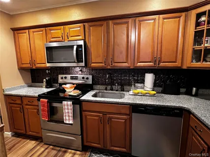 a kitchen with stainless steel appliances granite countertop a sink stove and cabinets