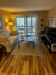 a living room with a couch and a potted plant next to a window