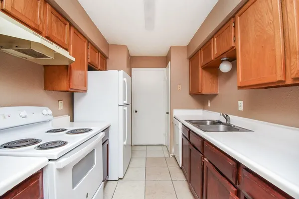 a kitchen with a sink a stove and a refrigerator