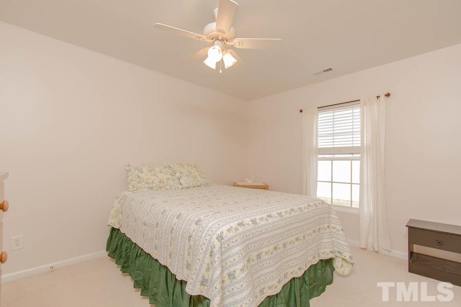 8147 Rhiannon Road Raleigh, NC 27613 - Photo 12 of 19 a bedroom with a bed and a chandelier