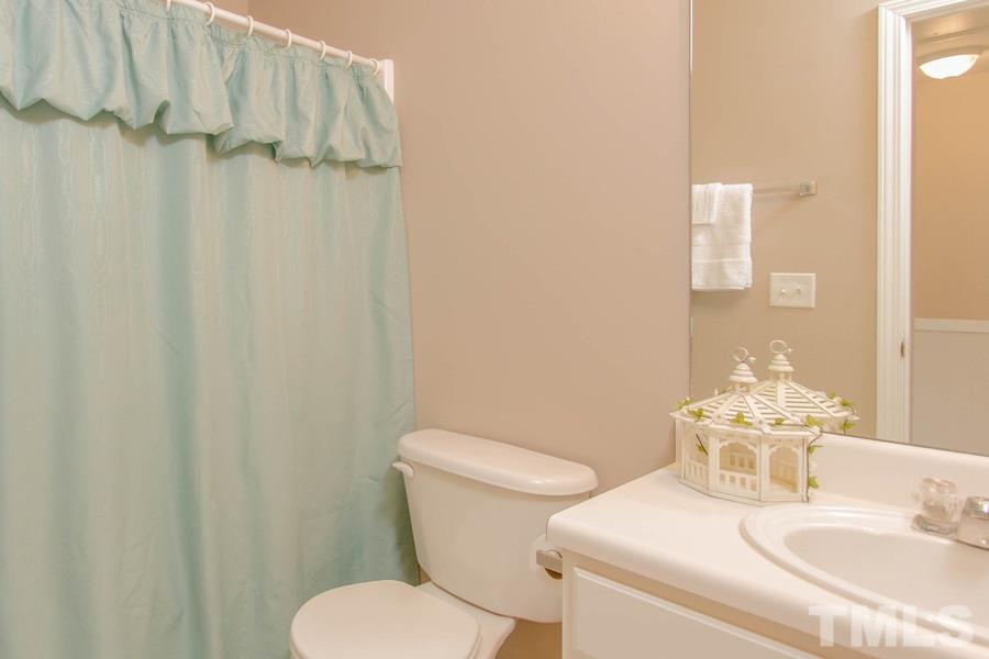 8147 Rhiannon Road Raleigh, NC 27613 - Photo 13 of 19 a white toilet sitting next to a bathroom sink