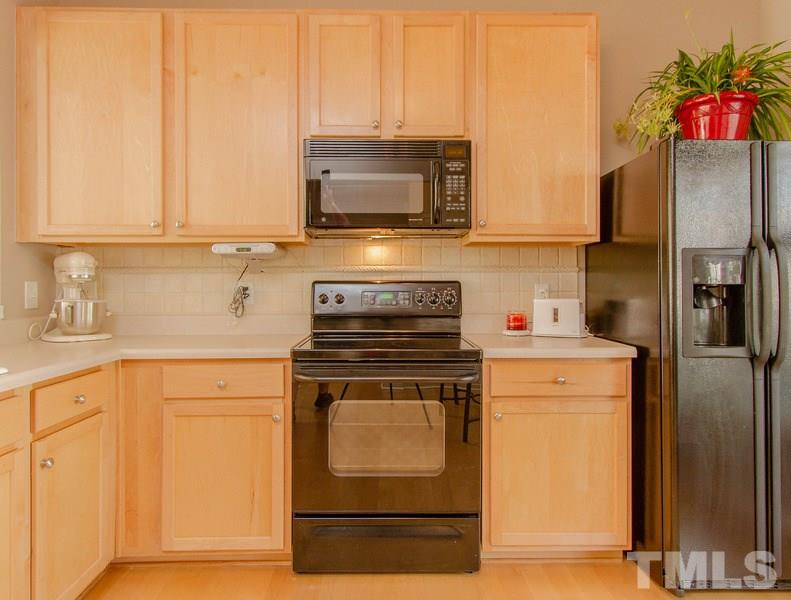 8147 Rhiannon Road Raleigh, NC 27613 - Photo 6 of 19 a kitchen with a stove microwave and refrigerator