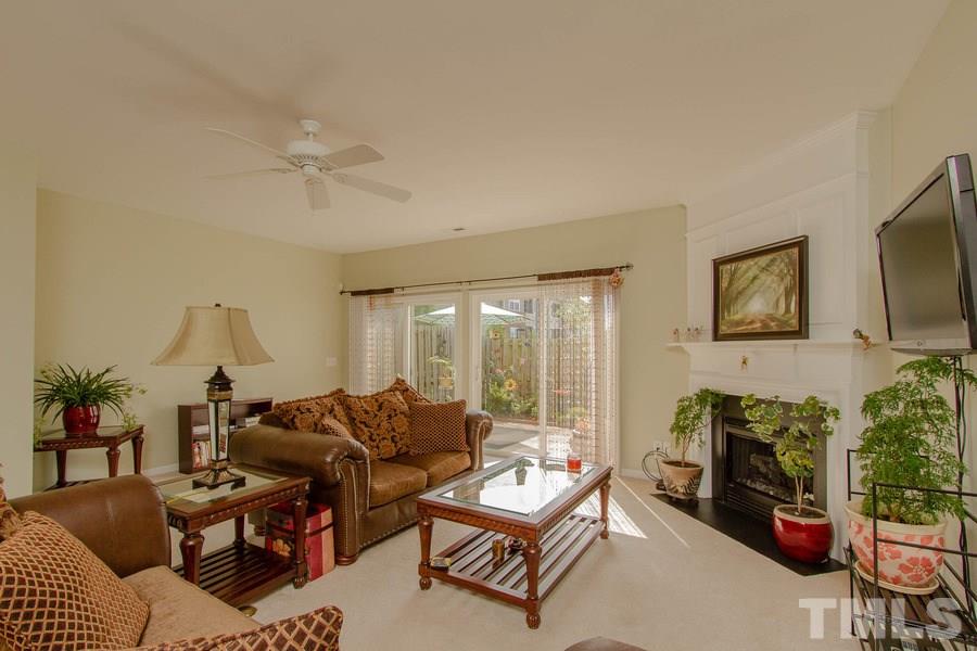 8147 Rhiannon Road Raleigh, NC 27613 - Photo 7 of 19 a living room with furniture a flat screen tv and a large window