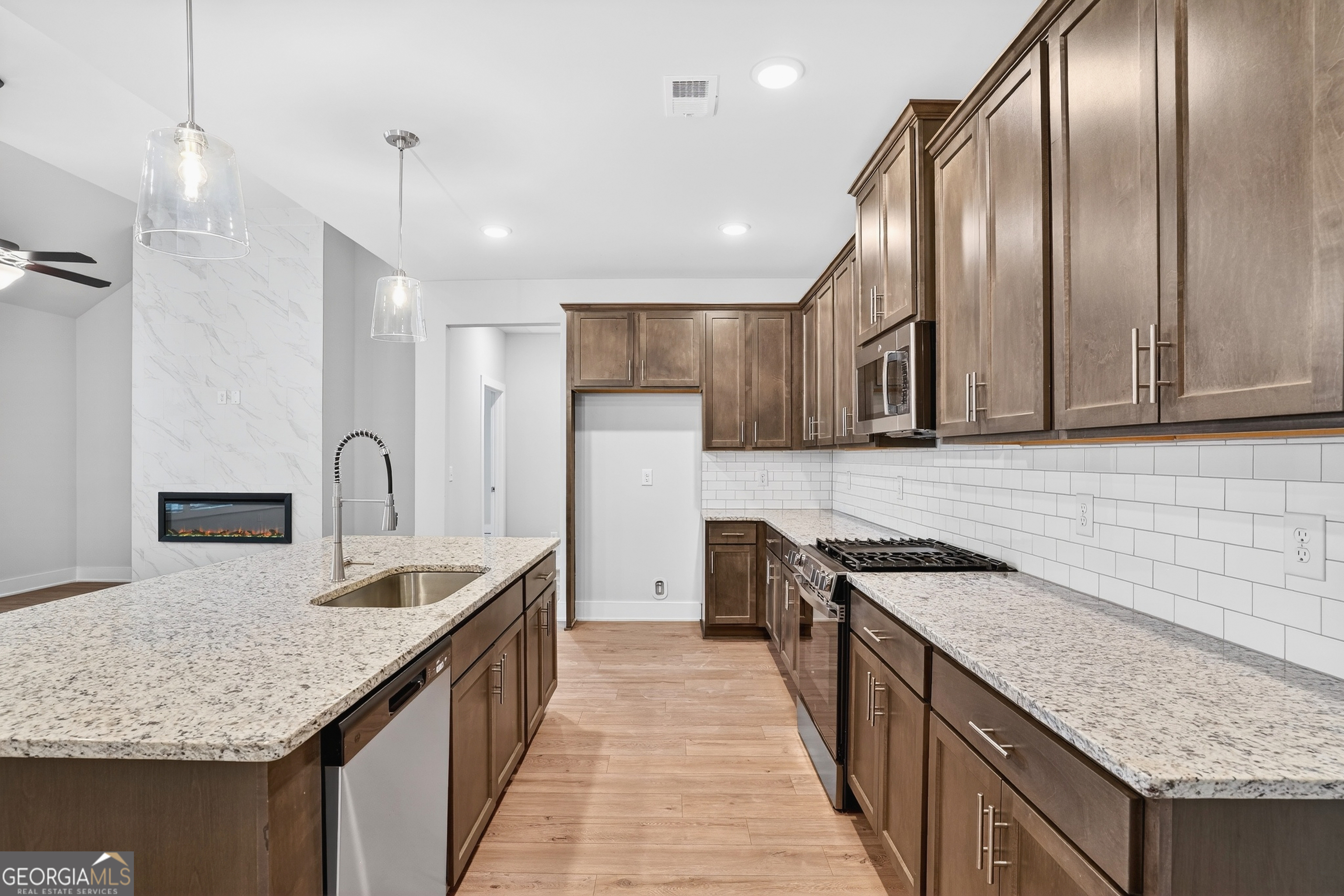 214 Villa Rica Springs Villa Rica, GA 30180 - Photo 11 of 33 Gourmet galley-style kitchen with granite countertops, subway tile backsplash, stainless steel appliances, and abundant cabinet space.
