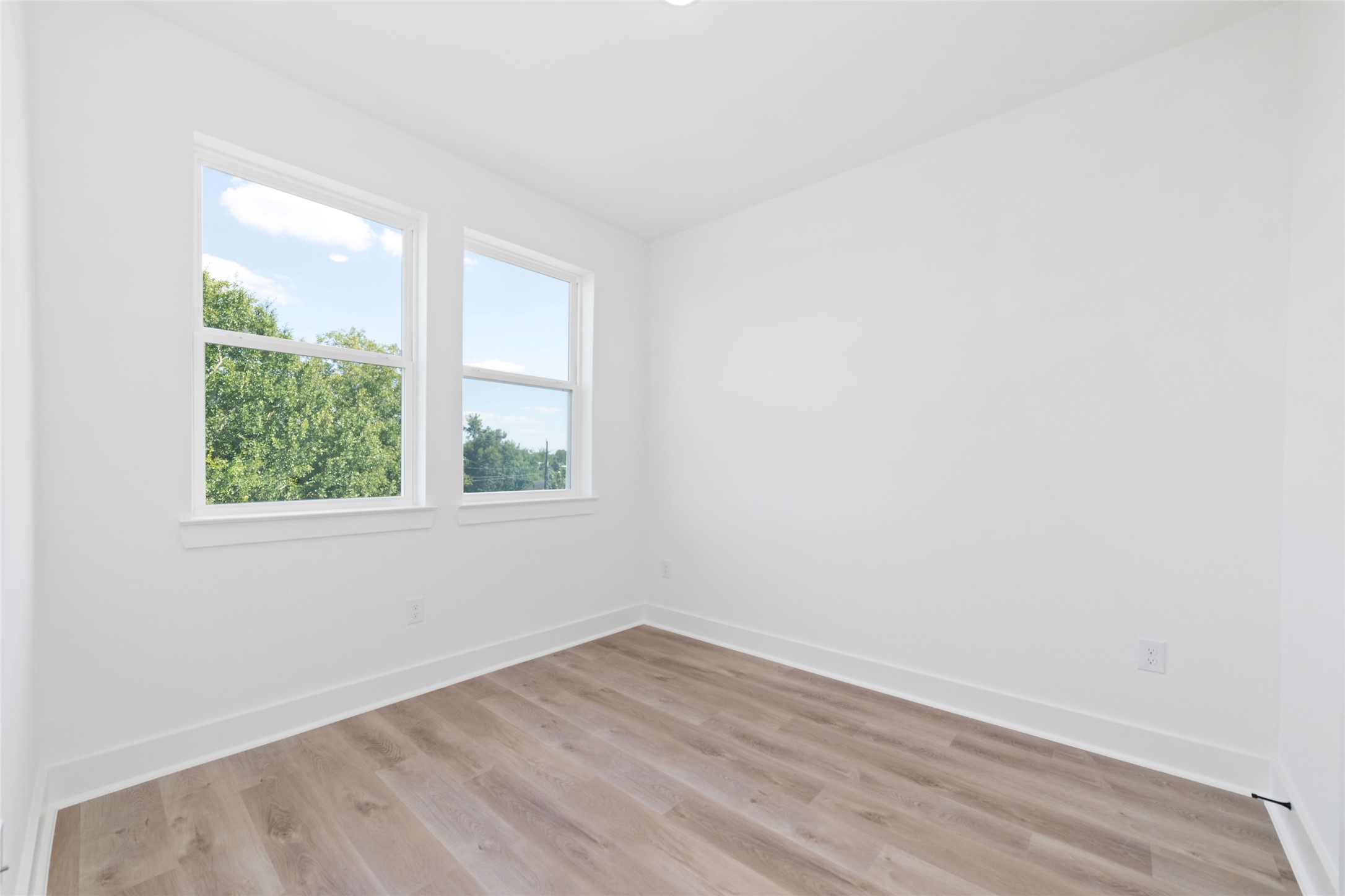 810 Elkhart Street, Unit B Houston, TX 77091 - Photo 30 of 50 an empty room with wooden floor and windows