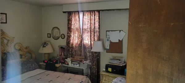 a bed sitting in a bedroom next to a window