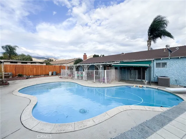an aerial view of a house with swimming pool and furniture