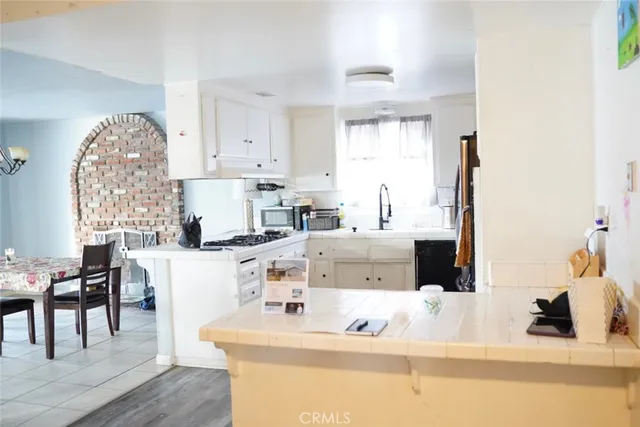 a living room with a couch and a dining table with wooden floor