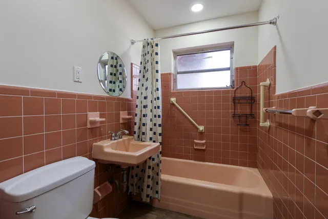 a bathroom with a sink a toilet and shower