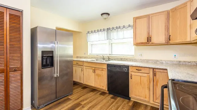 a kitchen with stainless steel appliances granite countertop a refrigerator and a sink