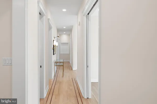 a large kitchen with kitchen island a stove a sink a refrigerator and white cabinets with wooden floor