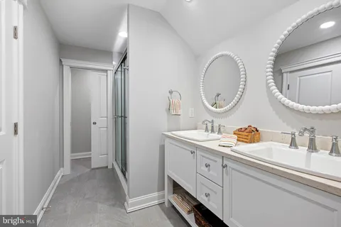 a bathroom with a glass shower door and a mirror