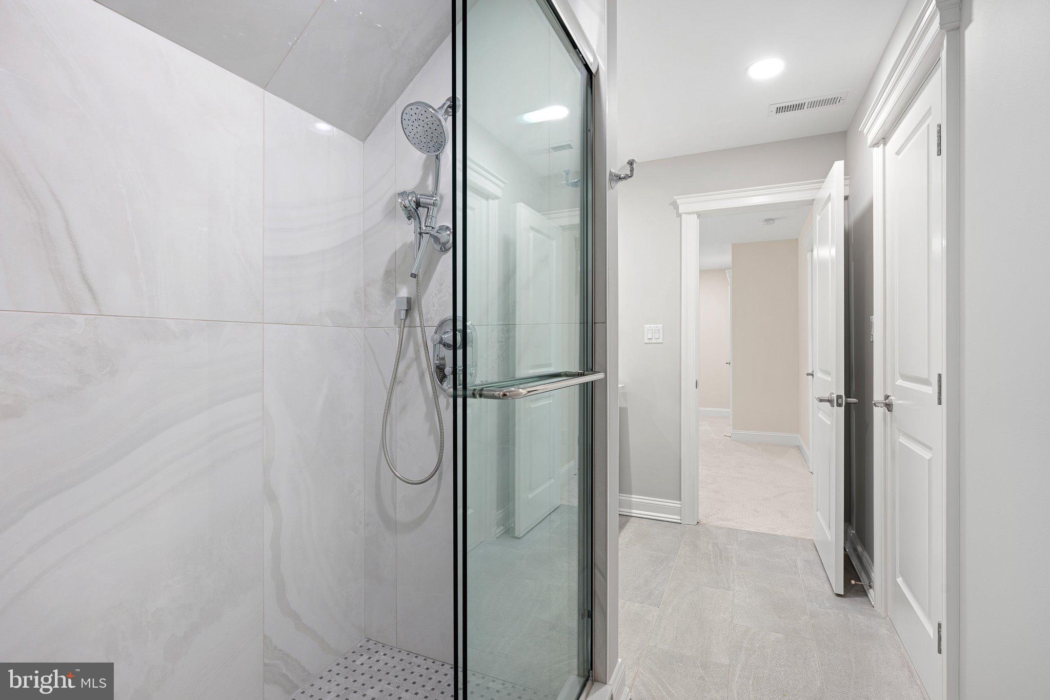 403 Canal Way East Bethany Beach, DE 19930 - Photo 39 of 51 a bathroom with a glass shower door and a mirror