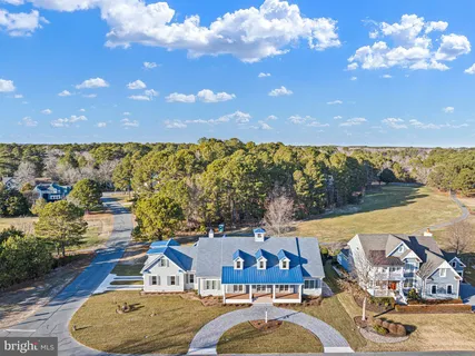 a front view of a house with a yard and lake view