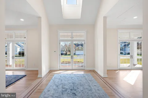 a view of an empty room with wooden floor and windows