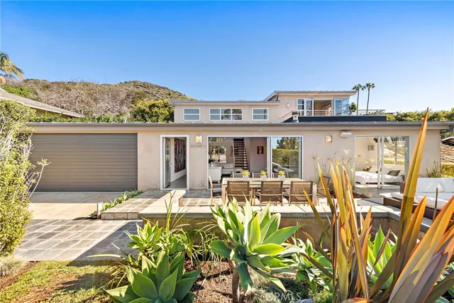 a front view of a house with swimming pool and sitting area