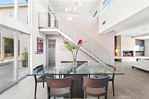 a view of a dining room with furniture a potted plant and wooden floor