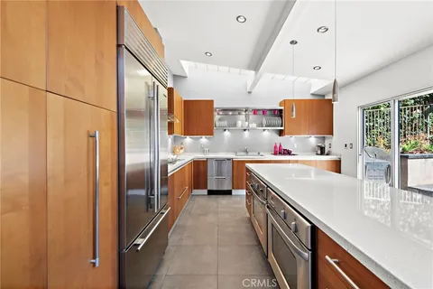 a kitchen with stainless steel appliances granite countertop a sink a stove and a refrigerator