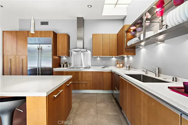 a kitchen with stainless steel appliances granite countertop a sink and a refrigerator