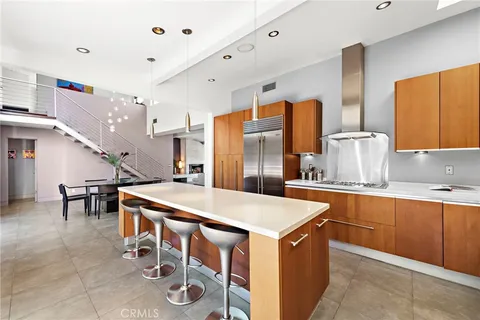 a kitchen with stainless steel appliances a table chairs and a refrigerator