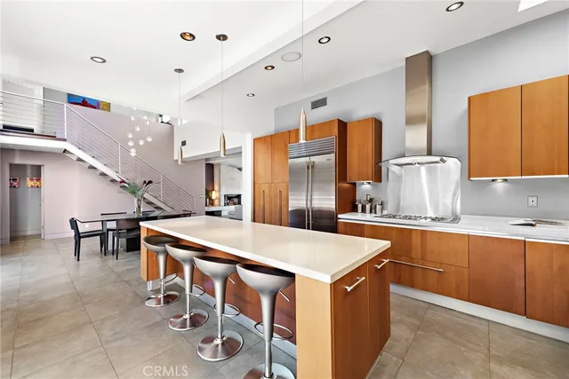 a kitchen with stainless steel appliances a table chairs and a refrigerator