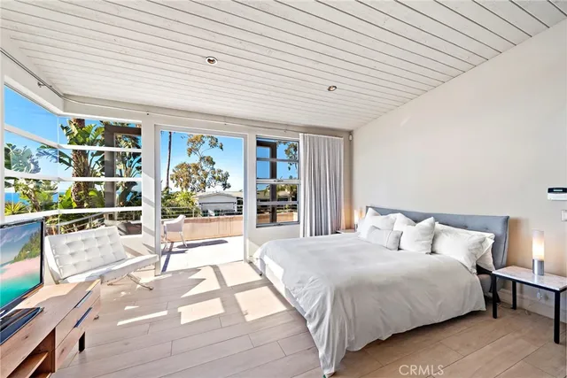 a spacious bedroom with a large bed a rug and potted plant
