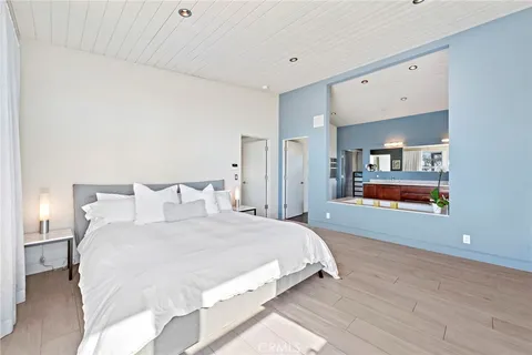 a spacious bedroom with a bed and a painting on the wall