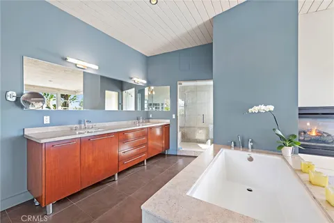 a spacious bathroom with a tub double sink and mirror