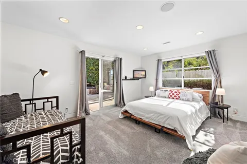 a bedroom with a bed a table and windows