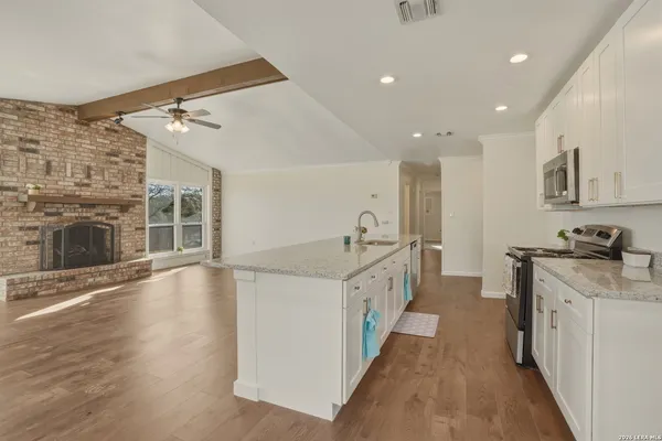 a kitchen with stainless steel appliances granite countertop a sink stove and cabinets
