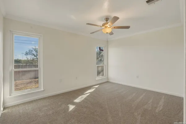 an empty room with a ceiling fan and a window