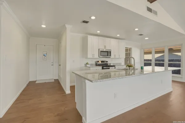 a kitchen with stainless steel appliances granite countertop a sink stove and cabinets
