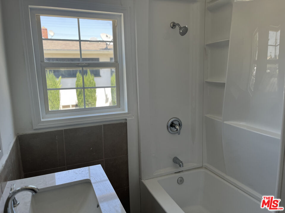 602 North Sloan Avenue Compton, CA 90221 - Photo 12 of 16 a bathroom with a tub and a window