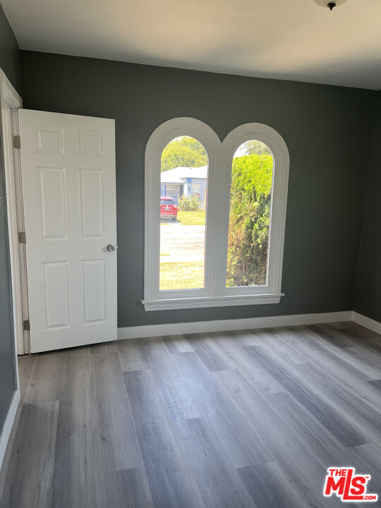 602 North Sloan Avenue Compton, CA 90221 - Photo 14 of 16 an empty room with wooden floor and windows