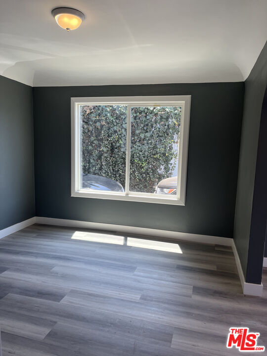 602 North Sloan Avenue Compton, CA 90221 - Photo 10 of 16 a view of an empty room with wooden floor and a window