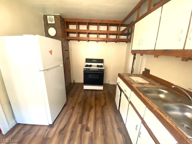 1763 Algonac Road Cleveland, OH 44112 - Photo 19 of 31 Kitchen featuring white appliances, white cabinets, dark hardwood / wood-style flooring, and sink